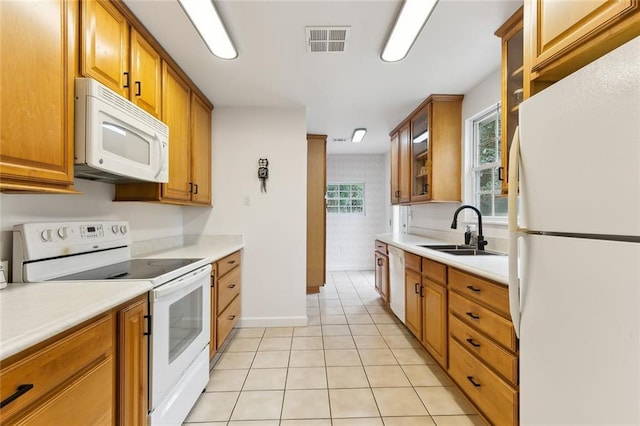 kitchen with sink, white appliances, and light tile patterned flooring