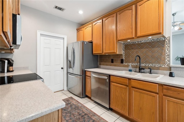 kitchen featuring tasteful backsplash, appliances with stainless steel finishes, sink, and light tile patterned floors