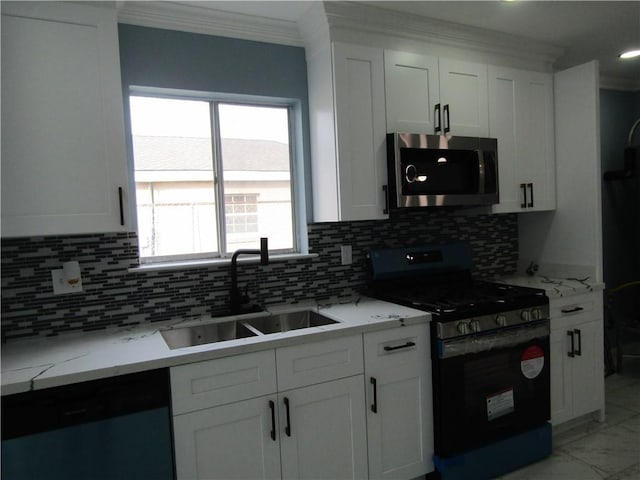 kitchen with sink, appliances with stainless steel finishes, light stone countertops, ornamental molding, and white cabinets