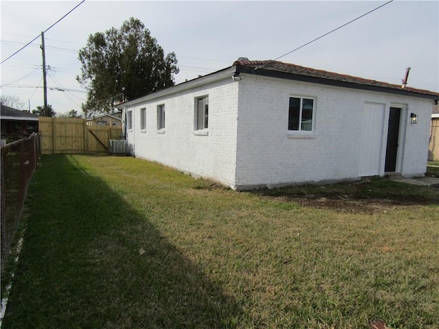 view of side of property with cooling unit and a lawn