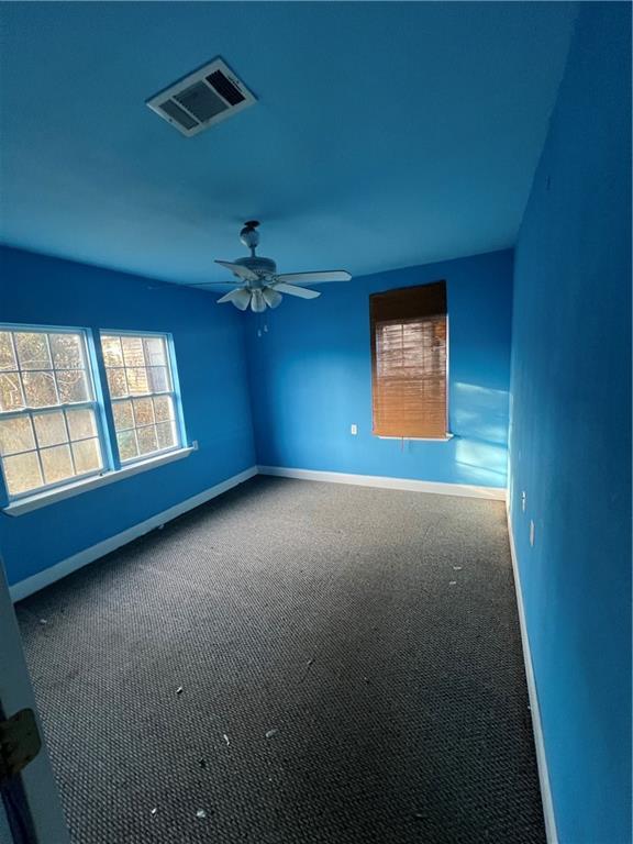 carpeted spare room featuring ceiling fan