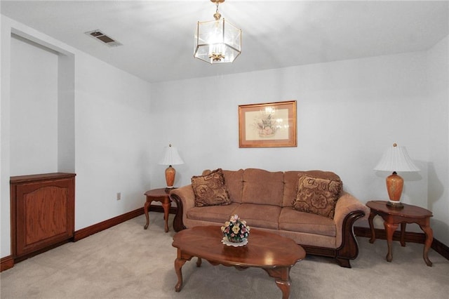 carpeted living room featuring a chandelier