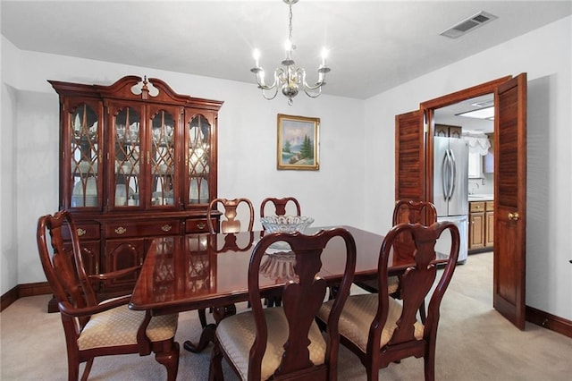 carpeted dining space featuring a notable chandelier