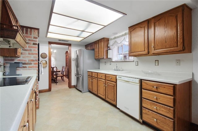 kitchen with dishwasher, sink, stainless steel fridge, custom exhaust hood, and black electric stovetop