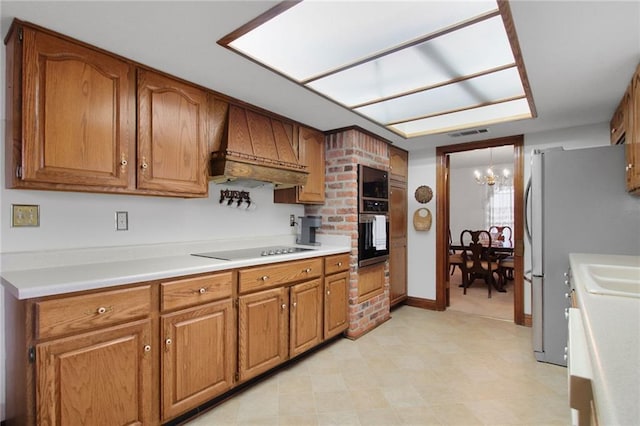 kitchen featuring appliances with stainless steel finishes, custom range hood, and a notable chandelier