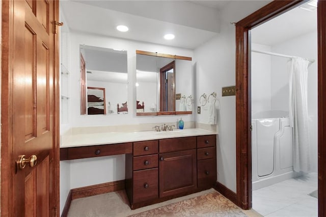 bathroom with walk in shower and vanity