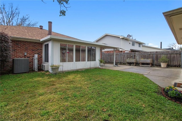 view of yard with a sunroom, a patio, and central air condition unit