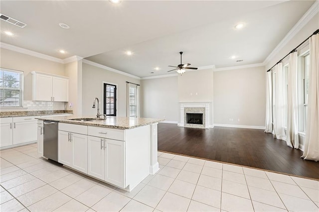 kitchen with white cabinetry, sink, a center island with sink, and light tile patterned floors