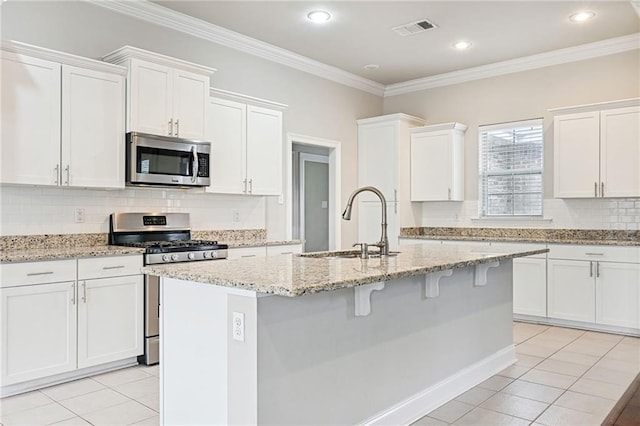 kitchen with sink, light tile patterned floors, white cabinets, and appliances with stainless steel finishes