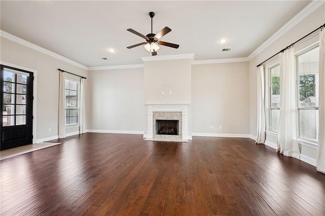 unfurnished living room with dark hardwood / wood-style flooring, a high end fireplace, and a healthy amount of sunlight