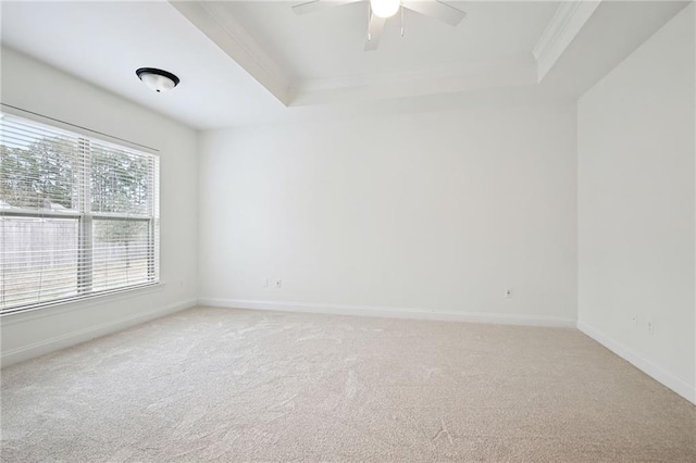 carpeted empty room with a tray ceiling, ornamental molding, and ceiling fan