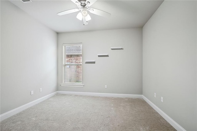 empty room featuring ceiling fan and carpet