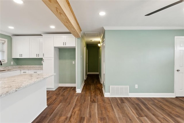 kitchen featuring white cabinetry, sink, crown molding, and light stone counters