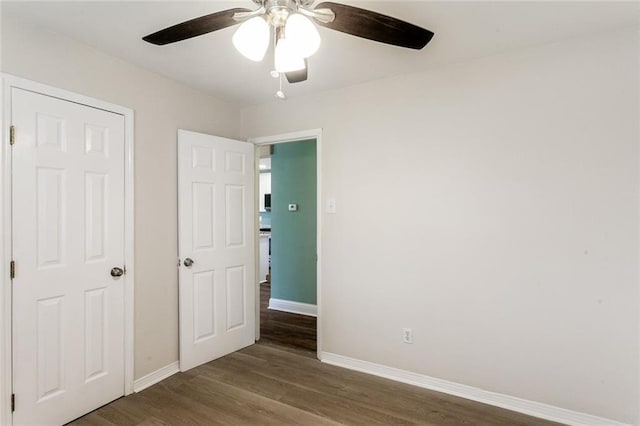 unfurnished bedroom with dark wood-type flooring and ceiling fan