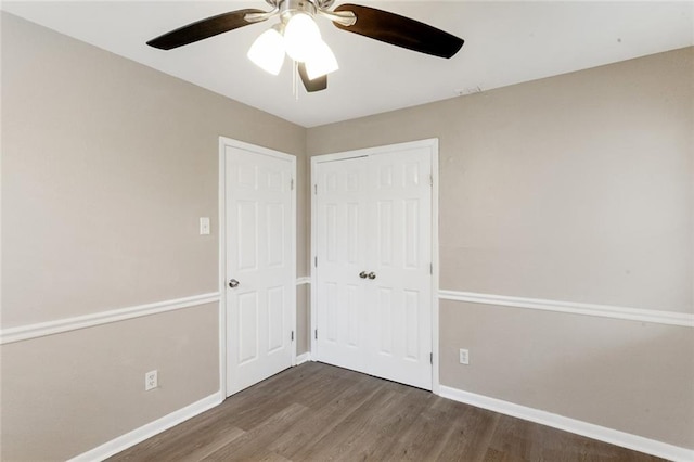 unfurnished bedroom with dark hardwood / wood-style floors, ceiling fan, and a closet