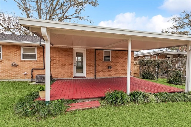 back of property featuring a wooden deck, a yard, and central AC