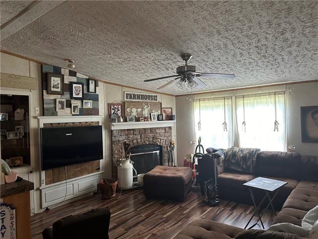 living room with a stone fireplace, crown molding, wood-type flooring, vaulted ceiling, and ceiling fan