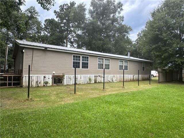 back of house with a lawn