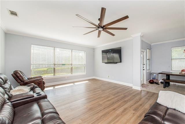 living room featuring ceiling fan, ornamental molding, and light hardwood / wood-style flooring