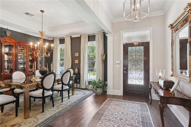 entryway with ornamental molding, dark hardwood / wood-style flooring, and a chandelier