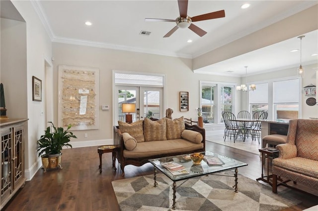 living room with french doors, ornamental molding, dark hardwood / wood-style floors, and ceiling fan with notable chandelier