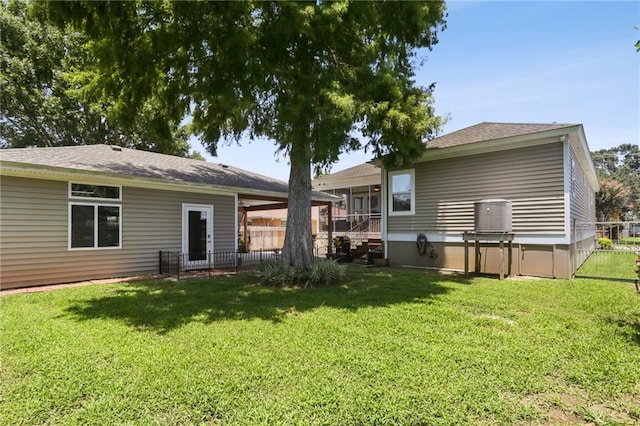 rear view of property featuring a sunroom and a lawn