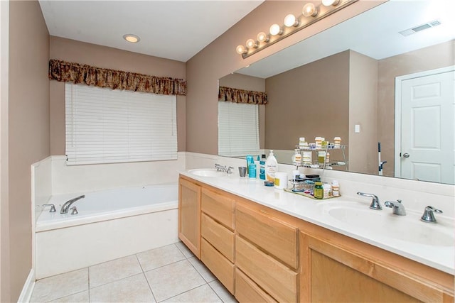 bathroom featuring tile patterned flooring, vanity, and a tub to relax in