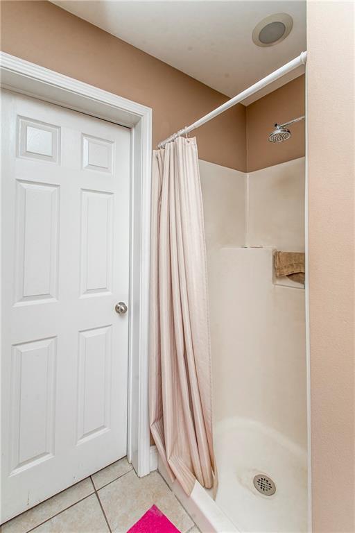 bathroom featuring tile patterned flooring and curtained shower