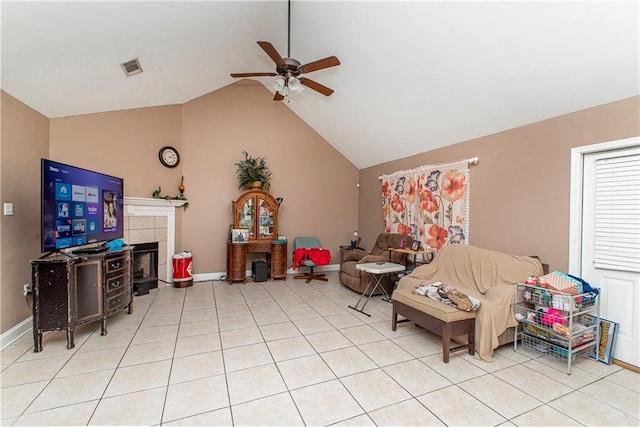 living room featuring ceiling fan, lofted ceiling, a tile fireplace, and light tile patterned floors