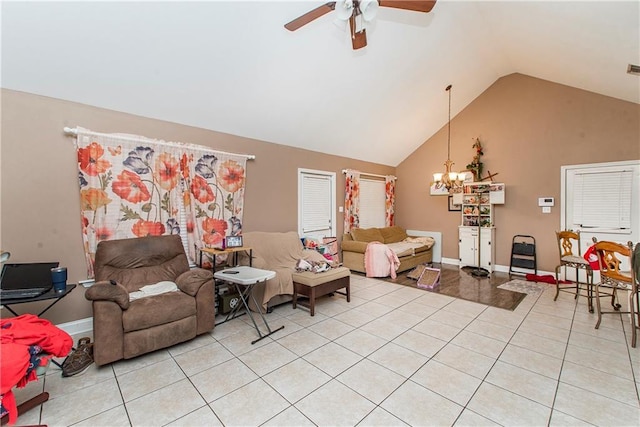 tiled living room with lofted ceiling and ceiling fan with notable chandelier