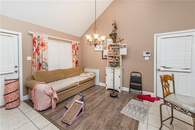 tiled living room with vaulted ceiling and a notable chandelier