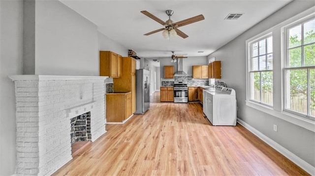 kitchen with ceiling fan, appliances with stainless steel finishes, plenty of natural light, washer / dryer, and visible vents