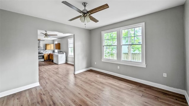 unfurnished living room featuring baseboards, a ceiling fan, and wood finished floors