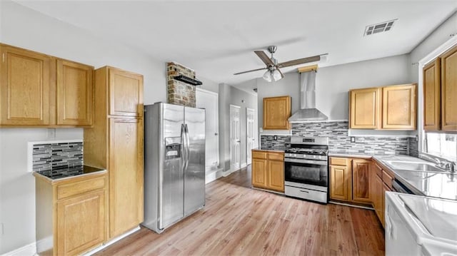 kitchen with a ceiling fan, visible vents, appliances with stainless steel finishes, tasteful backsplash, and wall chimney exhaust hood