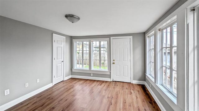 spare room featuring baseboards and wood finished floors