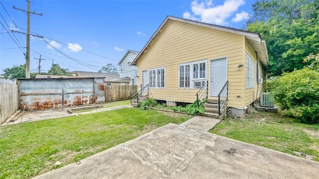 rear view of house featuring a lawn, a fenced backyard, and entry steps