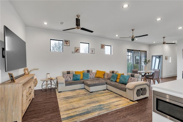 living room featuring ceiling fan and dark hardwood / wood-style flooring