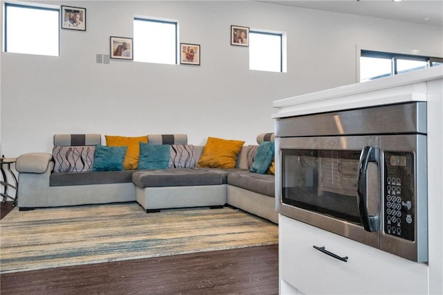 living room with plenty of natural light and dark hardwood / wood-style flooring