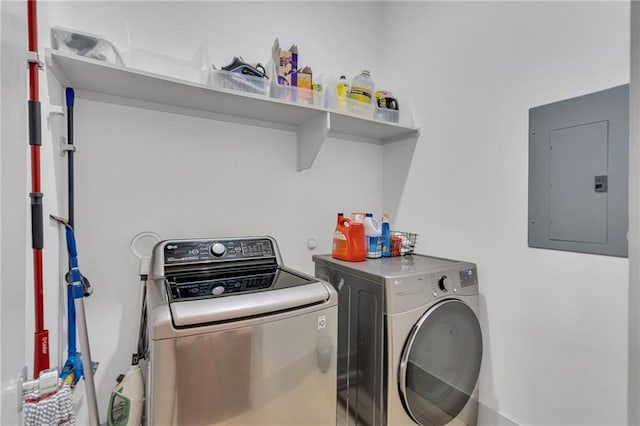 washroom featuring electric panel and washer and clothes dryer