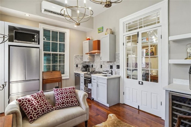 kitchen featuring an inviting chandelier, beverage cooler, a wall mounted air conditioner, dark wood finished floors, and stainless steel appliances