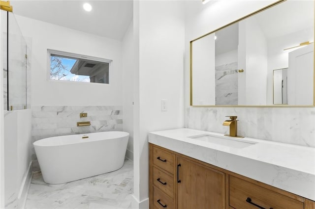 bathroom with vanity, a bath, and tile walls