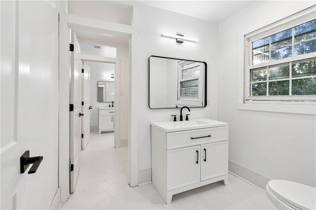 bathroom featuring vanity, tile patterned flooring, and toilet