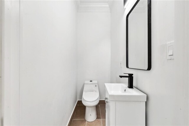 bathroom with vanity, ornamental molding, tile patterned floors, and toilet