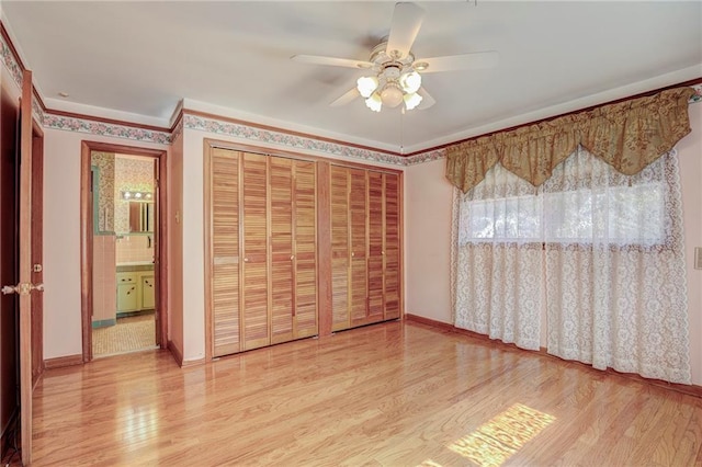 unfurnished bedroom featuring ceiling fan, crown molding, connected bathroom, and light hardwood / wood-style floors