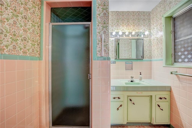 bathroom featuring tile walls, vanity, and a shower with door