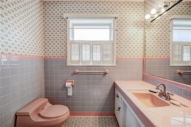 bathroom featuring tile patterned floors, toilet, vanity, and a wealth of natural light