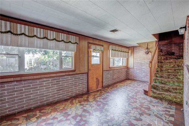 empty room featuring brick wall