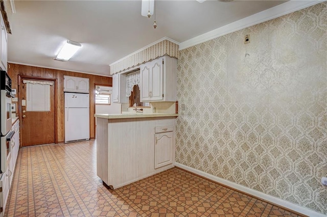 kitchen featuring ornamental molding, kitchen peninsula, and white fridge