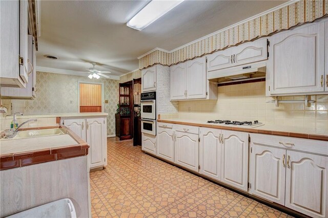 kitchen with crown molding, tile counters, ceiling fan, and white appliances