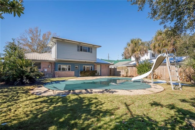 view of swimming pool with a water slide and a lawn